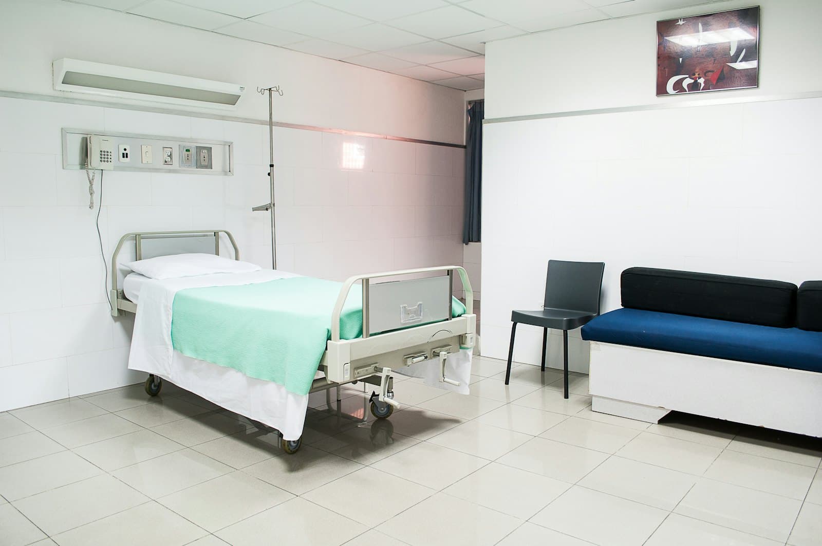 A private hospital room with a patient bed and seating