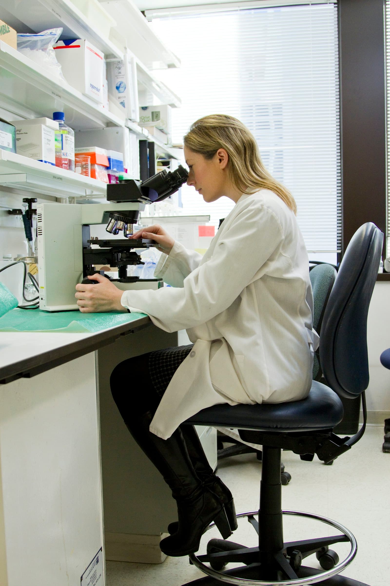 A laboratory professional working at a microscope